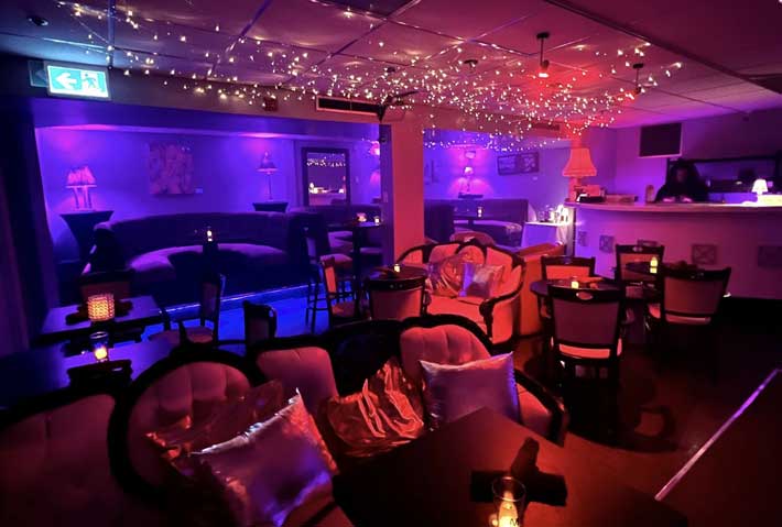 Lounge bar du Club L — ambiance tamisée et fauteuils de salon